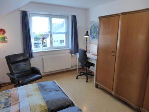 1 dormitorio con cama, escritorio y silla en 22 – Zimmer & Zmorge, en Kreuzlingen