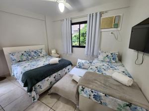 1 Schlafzimmer mit 2 Betten und einem Flachbild-TV in der Unterkunft AP Alecrim Porto Real Resort Vista Magnifica SPA Marina Praia Privada 3 suítes in Mangaratiba