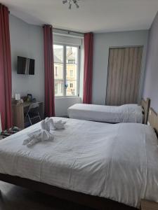 una camera d'albergo con due letti e una finestra di Le petit Védaquais a Vaas