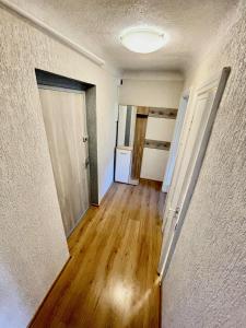 an empty room with a door and wooden floors at SMILE in Ventspils