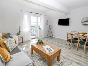 uma sala de estar com um sofá e uma mesa em Sea La Vie em Benllech