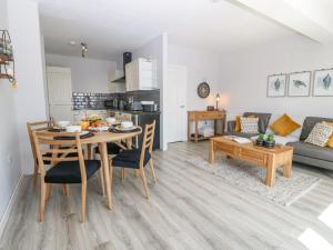 a kitchen and living room with a table and chairs at Sea La Vie in Benllech