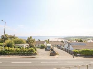 a street with houses and the ocean in the background at Sea La Vie in Benllech