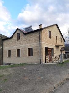 a large brick house with a balcony on top of it at Shen toon guesthouse in Shnogh