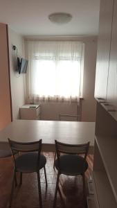 チヴィダーレ・デル・フリウーリにあるAlloggio Agrituristico Ronchi Di Fornalisのキッチン(椅子2脚、テーブル付)、窓が備わります。