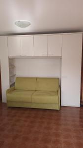 a green couch in a room with white cabinets at Alloggio Agrituristico Ronchi Di Fornalis in Cividale del Friuli