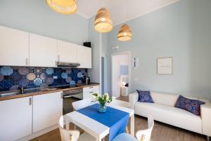 een keuken en een woonkamer met een tafel en een bank bij Mariviva Guest House in Terracina