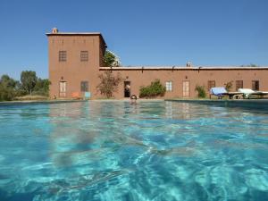 une piscine d'eau en face d'un bâtiment dans l'établissement Dar Tasmayoun, à Aït Ourir