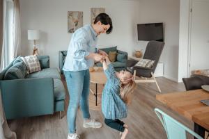 a woman playing with a child in a living room at Ferienhaus am Mühlenweiher 5 in Leutkirch im Allgäu