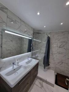 y baño con lavabo y espejo. en Appartement VUe MER avec parking gratuit sur place, en Bastia