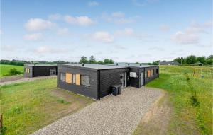 uma casa modular preta num campo relvado em 4 Bedroom Awesome Home In Lgstrup em Løgstrup
