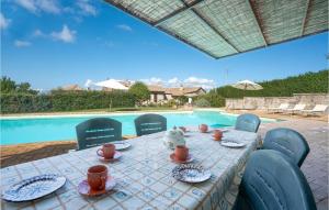 una mesa con tazas y platos junto a una piscina en Antonio, en Izzalini