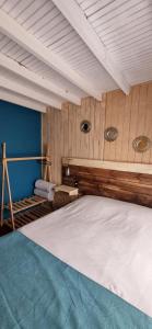 Cama grande en habitación con paredes de madera en Cabañas Costa Norte, en Algarrobo