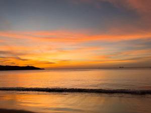 einen Sonnenuntergang am Strand mit dem Meer in der Unterkunft Rustic Beach Front Hotel Brasilito in Brasilito