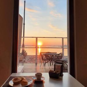 Habitación con vistas a un balcón con una mesa con donuts. en Albergo Del Sole en Taranto