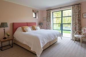 a bedroom with a large bed and a large window at Goodshelter Bay in Salcombe