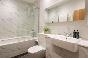 a bathroom with a sink and a toilet and a tub at Goodshelter Bay in Salcombe