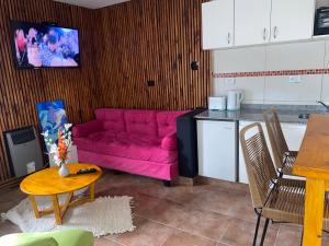 sala de estar con sofá rosa en la cocina en Don Bosco 1ro en Neuquén