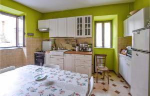 een keuken met een tafel en een keuken met groene muren bij 2 Bedroom Stunning Home In Borgia in Borgia