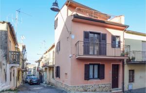 een roze gebouw met een balkon in een straat bij 2 Bedroom Stunning Home In Borgia in Borgia
