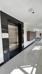 un couloir d'un immeuble avec ascenseur en métal brillant dans l'établissement Jannah’pad, à Manille