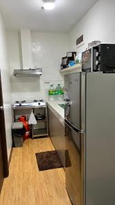 Il comprend une cuisine équipée d'un réfrigérateur en acier inoxydable et d'un comptoir. dans l'établissement Jannah’pad, à Manille