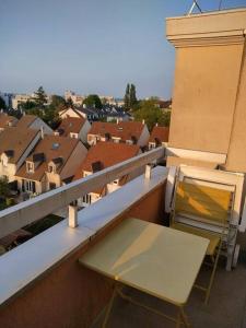 a table and a chair on a balcony with a city at Noisy-le-Grand/ Disneyland in Noisy-le-Grand