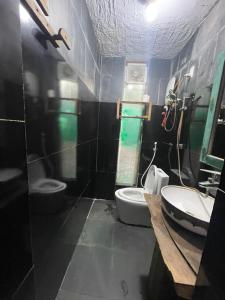 een badkamer met 2 toiletten en een wastafel bij Tiệm Cà Phê Mer Homestay & Coffee Mộc Châu in Mộc Châu