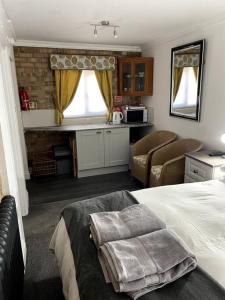 ein Schlafzimmer mit einem Bett und eine Küche mit einer Mikrowelle in der Unterkunft 31 Elwyn Snug in March