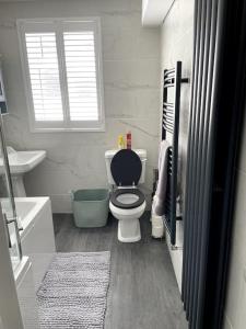 een witte badkamer met een toilet en een raam bij 31 Elwyn Snug in March