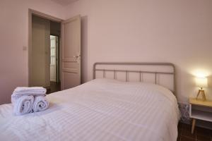 una camera da letto con un letto bianco con due asciugamani di Bel Appartement T3 a Carcassonne