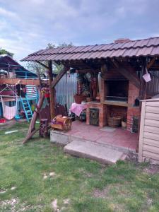 a patio with a roof and a grill in a yard at Casa Denis rustic in Turda +10 photos