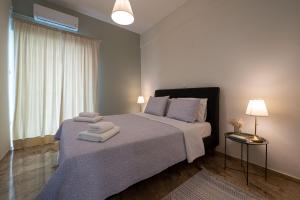 a bedroom with a large bed with towels on it at Anesis with a Yard in Kalamata