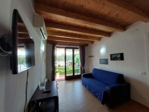sala de estar con sofá azul y TV en Pizzocolo resort fasano, en Gardone Riviera