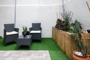 a patio with three chairs and a table and plants at Anesis with a Yard in Kalamata