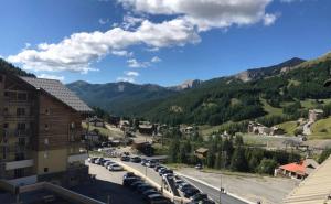 una vista de una ciudad con coches aparcados en un aparcamiento en Appartement charmant - Allos, en Allos