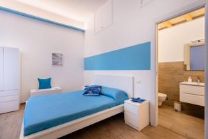a bedroom with a blue bed and a sink at Mariviva Guest House in Terracina
