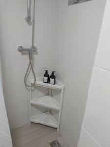 a white shelf with two bottles on it in a bathroom at BeachFront House in Málaga