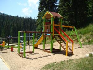 einen Spielplatz mit Rutsche im Sand in der Unterkunft апартамент Крис 513 Stream tesort in Pamporowo