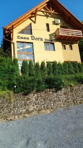 a building with a stone wall in front of it at Casa Dora in Sovata