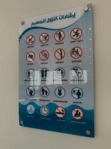 a sign in a bathroom with various signs on it at شاليه اوبل قاردن - OPAL GARDENS in Al Baha