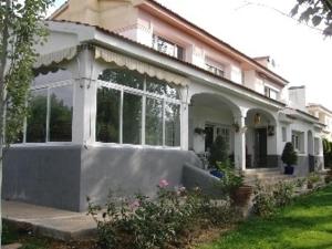 una grande casa bianca con una grande finestra di casa chalet El Sotillo a Cuenca