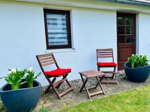twee stoelen en een tafel voor een huis bij Ferienhaus in Rostock - Brinckmansdorf in Rostock