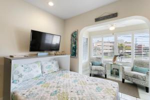 a bedroom with a bed and a flat screen tv at Funshine Pointe Capri in St Pete Beach