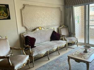 sala de estar con 2 sillas y sofá en Shata Apartment - Families Only, en El Cairo