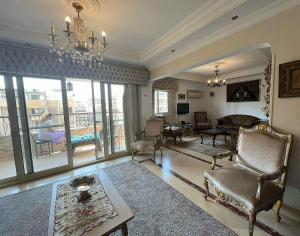 a living room with a chandelier and a living room with a couch at Shata Apartment - Families Only in Cairo