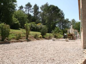 une allée en gravier avec un jardin en arrière-plan dans l'établissement Belle Villa provençale avec piscine à Brignoles, à Brignoles
