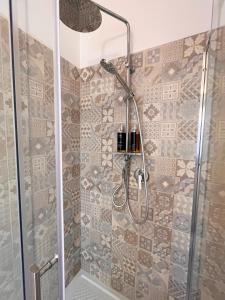 baño con ducha y puerta de cristal en Regina Margherita B&B, en Marzamemi