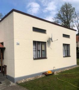 a white house with a frisbee in front of it at Dom pod lasem in Ruciane-Nida