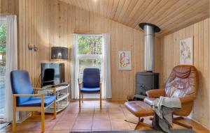 Nørre VorupørにあるAwesome Home In Thisted With 3 Bedrooms And Saunaのリビングルーム(椅子2脚、コンロ付)